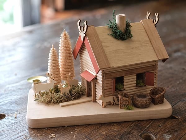 Winterliche Holzhütte mit Spanbäumen, Moos, Teelichthalter und Rehfiguren