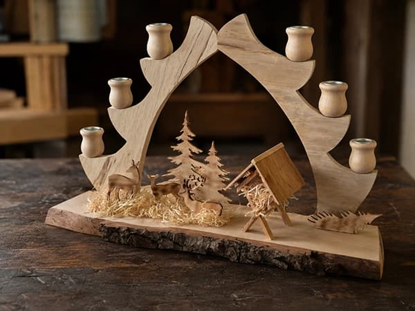 Schwibbogen aus Holz mit Waldstall, Rehen, Tannen und mehreren Kerzenhaltern