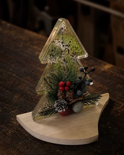 Transparenter Weihnachtsbaum mit Tannengrün, Beeren, Zapfen und Holzsockel