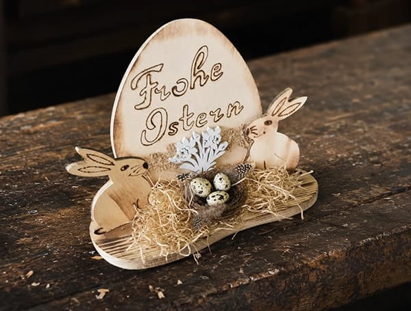 Holzaufsteller zu Ostern mit graviertem Ei, Hasen, Heu und kleinen Eiern